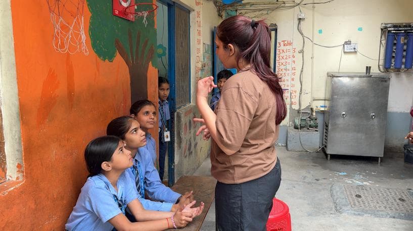 A Project Sahitya educator teaching two students at a partner Anganwadi centre